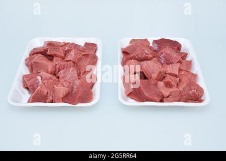 carni fresche di agnello disossate cubetti tritati in piastra, pezzi grezzi di montone non cotti closeup, macellaio tagliato Foto Stock