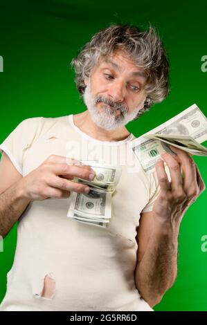 Uomo maturo con molti dollari, ansioso Foto Stock