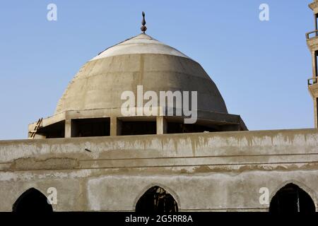 Una nuova moschea in costruzione contro il cielo azzurro soleggiato con il minareto moschea circondato da impalcature di legno e la cupola Foto Stock