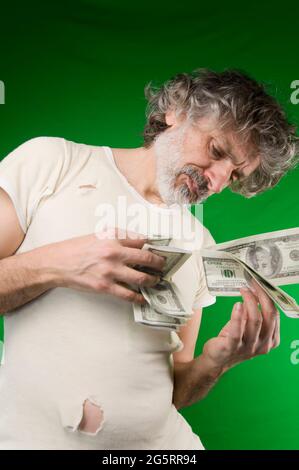 Uomo maturo con molti dollari, ansioso Foto Stock