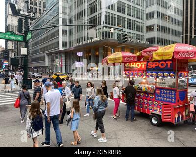 Il venditore di hot dog ha un posto fondamentale all'angolo tra la 6th Avenue e la 42nd Street, ad un'entrata principale del Bryant Park nel centro di Manhattan. Foto Stock