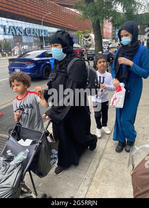 Madri musulmane coperte e mascherate con i ragazzi che si trovano nei pressi dell'Atlantic Mall, di fronte al Barclays Center di Brooklyn, New York. Foto Stock