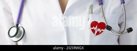 Brooch a forma di cuore appeso su uniforme di medico primo piano Foto Stock