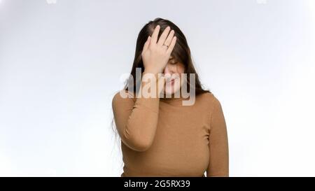 Studio ritratto di giovane donna deluso facendo facepalm gesto. Concetto di frustrazione e delusione Foto Stock