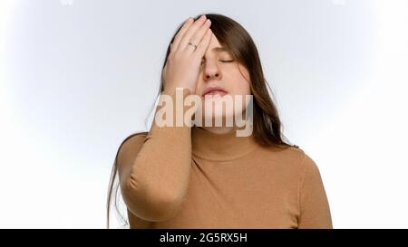 Studio ritratto di donna stressata e infastidita che fa gesto facepalm. Concetto di frustrazione e delusione. Foto Stock