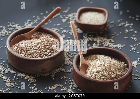 Set di diversi tipi di riso e cereali in ciotole di legno e. Foto Stock