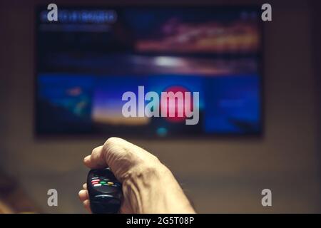 Maschio di mano che tiene il telecomando del TV. Foto Stock