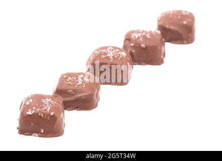 Pezzo di caramello salato coperto di cioccolato con sale spruzzato sopra Foto Stock