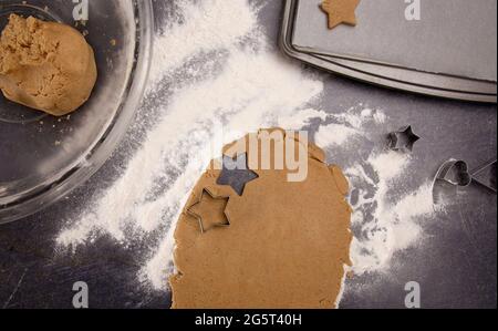 Biscotti di pan di zenzero che sono rotolati fuori e tagliati nelle stelle di Natale Foto Stock