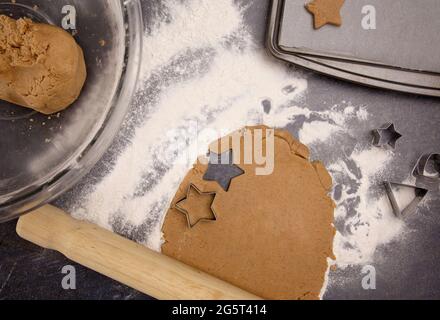 Biscotti di pan di zenzero che sono rotolati fuori e tagliati nelle stelle di Natale Foto Stock