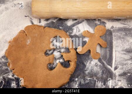 Biscotti di pan di zenzero che sono rotolati fuori e tagliati nelle persone Foto Stock