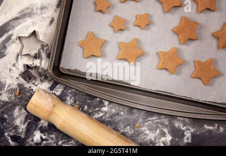 Biscotti di pan di zenzero che sono rotolati fuori e tagliati nelle stelle di Natale Foto Stock