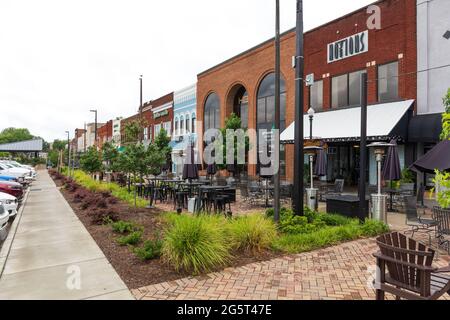 HICKORY, North Carolina, USA-22 GIUGNO 2021: Vista in prospettiva decrescente diagonale del centro 'Main Drag' che mostra edifici, arbusti colorati, marciapiede, tavoli Foto Stock