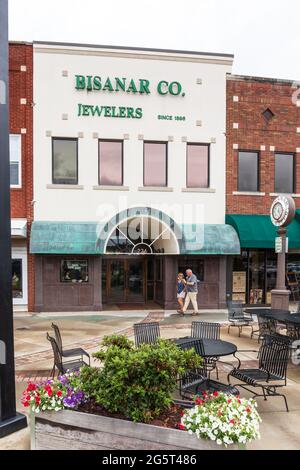 HICKORY, NC, USA-22 GIUGNO 2021: Vista frontale della costruzione della gioielleria Bisanar Co., con fiori colorati, orologio, tavoli e una coppia che cammina passato. Foto Stock