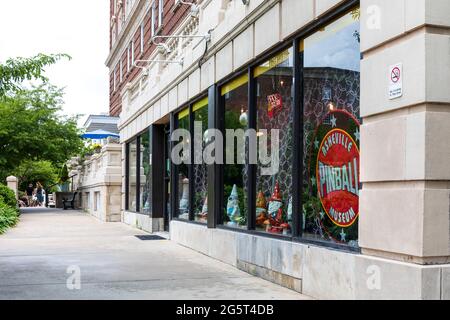 ASHEVILLE, NC, USA-27 Giugno 2021: Vista prospettica diagonale del Battery Park Hotel al piano terra che mostra Asheville Pinball Museum, marciapiede, persone a. Foto Stock