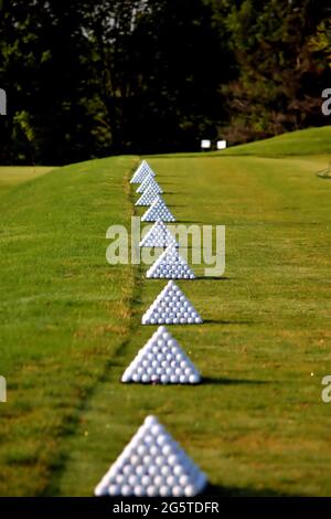 Palline da golf accatastate in piramidi pronte per il tempo di pratica Foto Stock