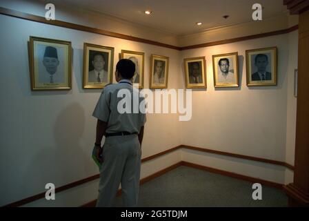 Giacarta, Indonesia. 7 aprile 2008. Un ufficiale del governo presta attenzione ai ritratti dei precedenti ministri della Sanità indonesiani esposti presso il muro del corridoio fuori dalla sala Leimena presso l'edificio degli uffici del ministero a Giacarta, dove si tiene un evento di media e seminari pubblici per celebrare la Giornata Mondiale della Sanità 2008. L'evento dei seminari è uno di una serie di eventi programmati per la celebrazione della Giornata Mondiale della Sanità 2008 nella capitale indonesiana. Il tema della celebrazione del 2008 è "proteggere la salute dai cambiamenti climatici". Foto Stock