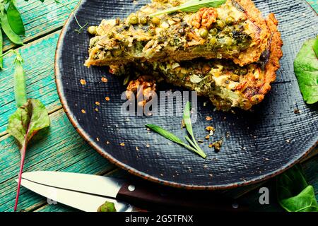 Torta fatta in casa con bietole, formaggio feta e piselli verdi. Torta con le erbe, nutrizione adeguata. Foto Stock