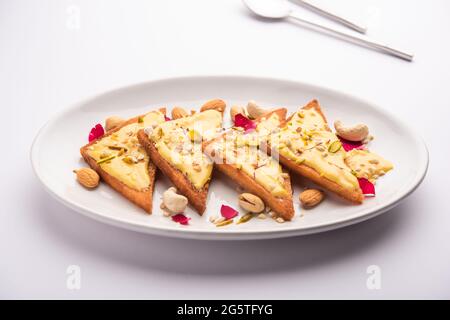 Shahi tukda o tukra, conosciuto anche come Double ka meetha, è un ricco e festoso dessert indiano fatto con pane, ghee, zucchero, latte e noci Foto Stock