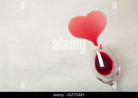 Pavimento in legno con bicchiere rovesciato di vino rosso. Vino versato su un pavimento in parquet laminato di legno con protezione contro l'umidità. Foto di alta qualità Foto Stock