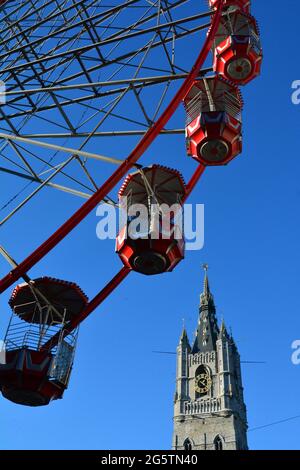 BELGIO. FIANDRE. GAND. GRANDE RUOTA DURANTE UNA FIERA CON IL CAMPANILE DI GAND (XIV SECOLO). ALTA 95 METRI, È UNA DELLE 'TRE TORRI' DEL CENTRO STORICO Foto Stock