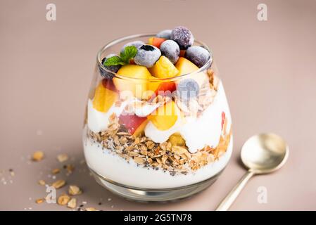 Prima colazione yogurt alla granola con pesca e mirtillo in un vaso, cibo sano, concetto di cibo pulito Foto Stock