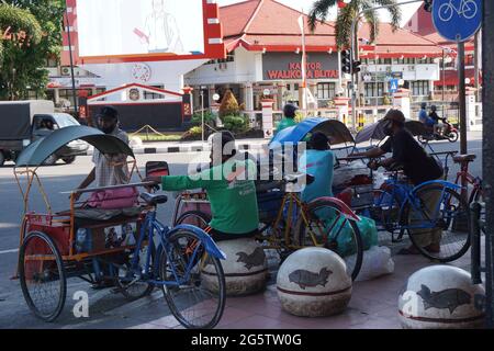 Becak sulla passeggiata laterale. Il becak e' uno dei tradizionali mezzi di trasporto indonesiani Foto Stock