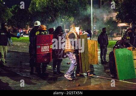 Bogotà, Colombia. 27 Giugno 2021. I membri della prima linea sono visti durante il confronto con la polizia anti-sommossa. Il 28 giugno ha segnato due mesi di proteste in Colombia. In molte città del paese si sono avuti blocchi e manifestazioni. In risposta, il governo ha dispiegato la polizia anti-sommossa, sparando gli scontri che hanno lasciato ferite centinaia di manifestanti. Credit: SOPA Images Limited/Alamy Live News Foto Stock