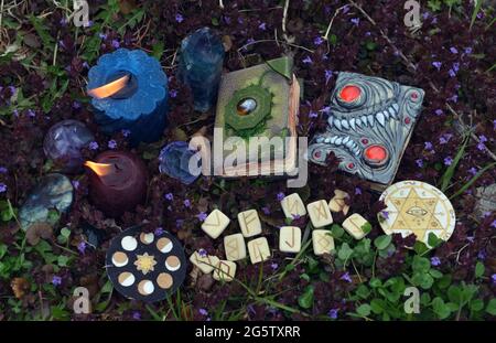 Ancora la vita con i libri magici della strega, rune, cristalli e candele brucianti fuori. Sfondo esoterico, gotico e occulto, Halloween mistico e wicca con Foto Stock