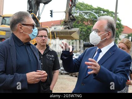 Dessau, Germania. 30 giugno 2021. Reiner Haseloff (CDU, r), primo ministro della Sassonia-Anhalt, parla con l'architetto Alfred Jacoby durante la sua visita al cantiere della nuova sinagoga di Dessau. La nuova sinagoga è in fase di costruzione nel luogo esatto in cui la vecchia sinagoga è stata distrutta nella notte del Progrom del 9 novembre 1938. Il completamento del nuovo edificio è previsto per l'inizio del 2022. Credit: Waltraud Grubitzsch/dpa-Zentralbild/ZB/dpa/Alamy Live News Foto Stock