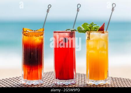 Set di rinfrescanti cocktail di frutta che si trovano a Table on Beach vicino al mare turchese Foto Stock