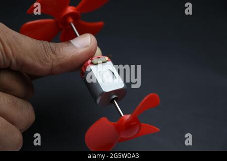 Il motore c.c. giocattolo con doppio albero con elica in plastica si collega alle sue estremità mostrando il concetto di progetti scientifici fatti in casa Foto Stock