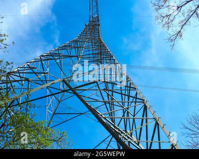 Pilone elettrico visto dal basso contro il cielo blu Foto Stock
