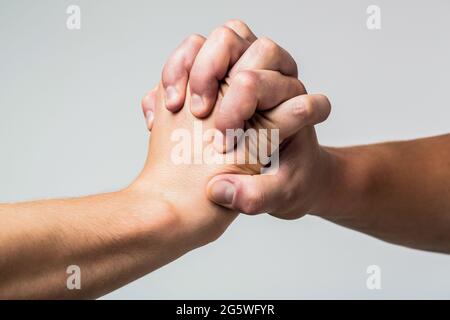 Mano maschile unita in stretta di mano. L'uomo aiuta le mani, la tutela, la protezione. Due mani, braccio isolato, mano di aiuto di un amico. Stretta di mano amichevole Foto Stock