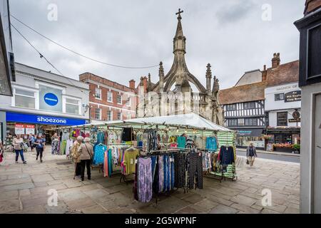 Stalla di vestiti davanti a Poultry Cross al mercato all'aperto di Martedì a Salisbury, Wiltshire, Regno Unito il 29 giugno 2021 Foto Stock