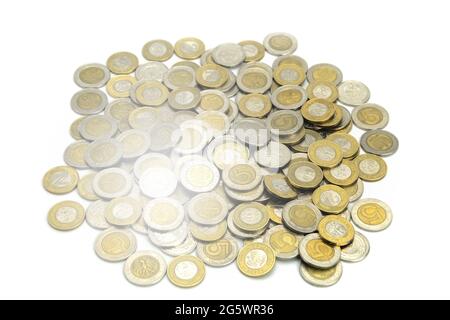 Monete di paesi diversi e denominazioni diverse su sfondo bianco. Monete europee e americane di paesi diversi primo piano, sole flare Foto Stock