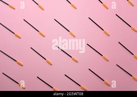 Sopracciglia e ciglia si spennellano su sfondo rosa pastello. Foto Stock