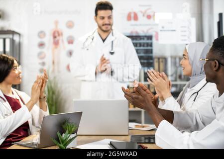 Gruppo di studenti internazionali giovani medici dell'università di medicina applaudendo il conferenziere o collega indiano competente. Processo educativo in classe interattiva. Condivisione con le conoscenze. Foto Stock