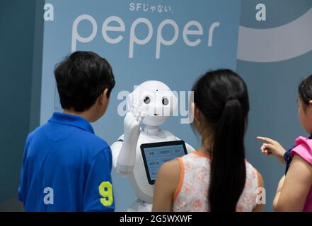 I bambini interagiscono con il robot di consumo umanoide di Softbank, Pepper in esposizione al Softbank Store Omotesando, Tokyo, Giappone. Venerdì 13 giugno 2014. Alla fine di giugno 2021, la società Softbank ha annunciato di aver tagliato i posti di lavoro nel settore della robotica globale e di aver interrotto la produzione del robot Pepper.il 28 giugno, La società Softbank ha annunciato tagli di posti di lavoro nel suo business globale della robotica e ha interrotto la produzione del suo robot Pepper annunciato nel 2014. Foto Stock