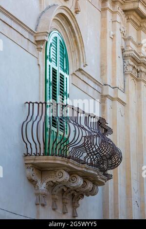 Noto, Siracusa, Sicilia, Italia. Suggestivo balcone in ferro battuto su façade del barocco Palazzo Astito di Fargione che si affaccia su Via Cavour. Foto Stock