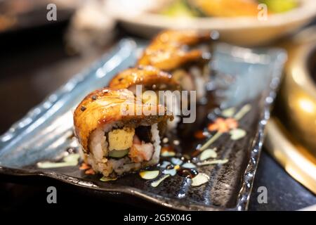Sushi di anguilla alla griglia su piatto nero. Cibo giapponese. Foto Stock