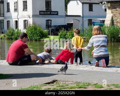 Famiglia che alimenta anatre sul canale Bude, Cornovaglia, Regno Unito Foto Stock