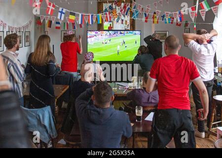 Gli appassionati dell'Inghilterra festeggiano battendo la Germania nel pub Prince George di East London durante il torneo di calcio Euro 2021 Foto Stock