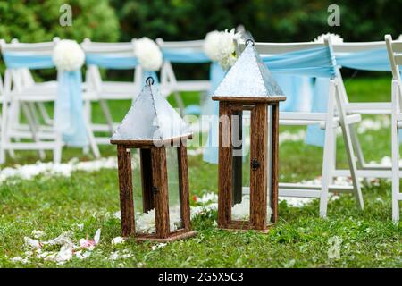 Decorazioni per cerimonie nuziali: Sedie con nastri e crisantemi, molti fiori in stile bianco e blu, su uno sfondo di verde Foto Stock