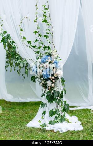 Decorazioni per cerimonie nuziali: Decorazioni ravvicinate dell'arco, decorate con crysantemi, rose, idrangee e vegetazione. Un sacco di fiori in bianco e blu Foto Stock