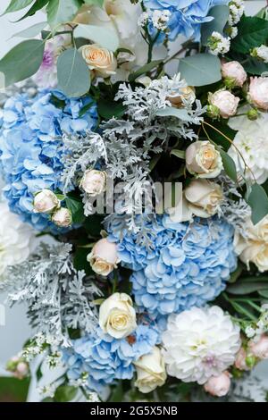 Decorazioni per cerimonie nuziali: Decorazioni ravvicinate dell'arco, decorate con crysantemi, rose, idrangee e vegetazione. Un sacco di fiori in bianco e blu Foto Stock