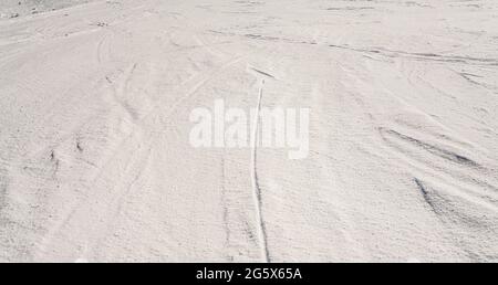 Pendio coperto di neve cristallina, pochi sentieri da sci visibile Foto Stock