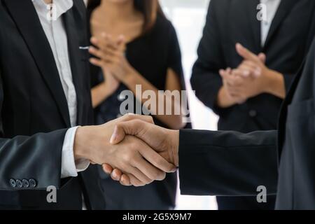 Business People gruppo handshake e clapping mano dopo aver finito la riunione di affari in ufficio, congratulazioni per la promozione, partenariato, successo, pa Foto Stock