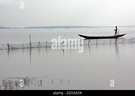 Foto del lago Chilka a Rambha, Odisha. Un pescatore sta andando pescare nel lago con la sua barca. Foto Stock