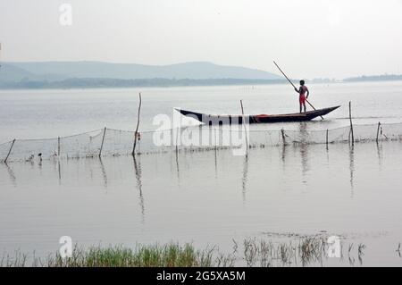 Foto del lago Chilka a Rambha, Odisha. Un pescatore sta andando pescare nel lago con la sua barca. Foto Stock